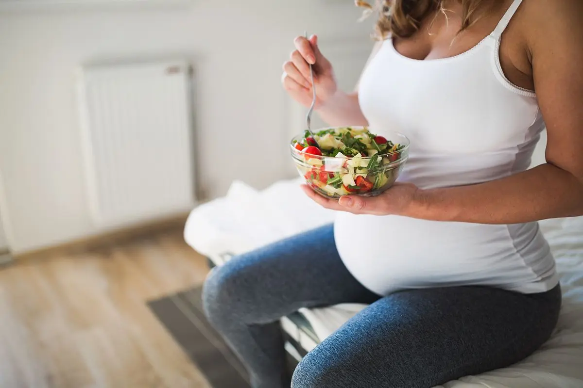 Pregnant woman eating salad
